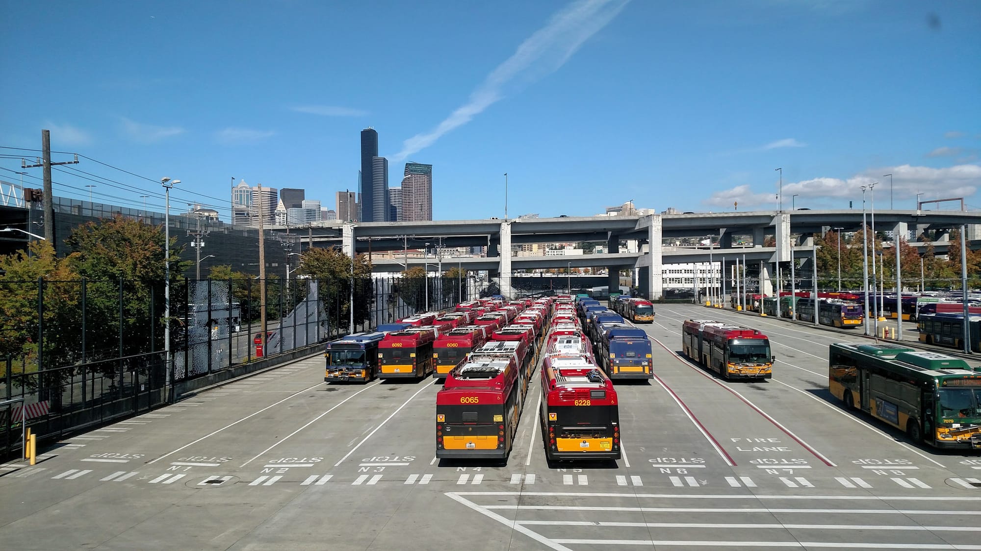 Rows of buses with the I-90 ramps and Seattle skyscrapers in the background.