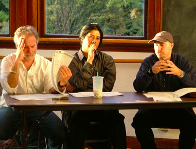 Photo of three men sitting at a table. 