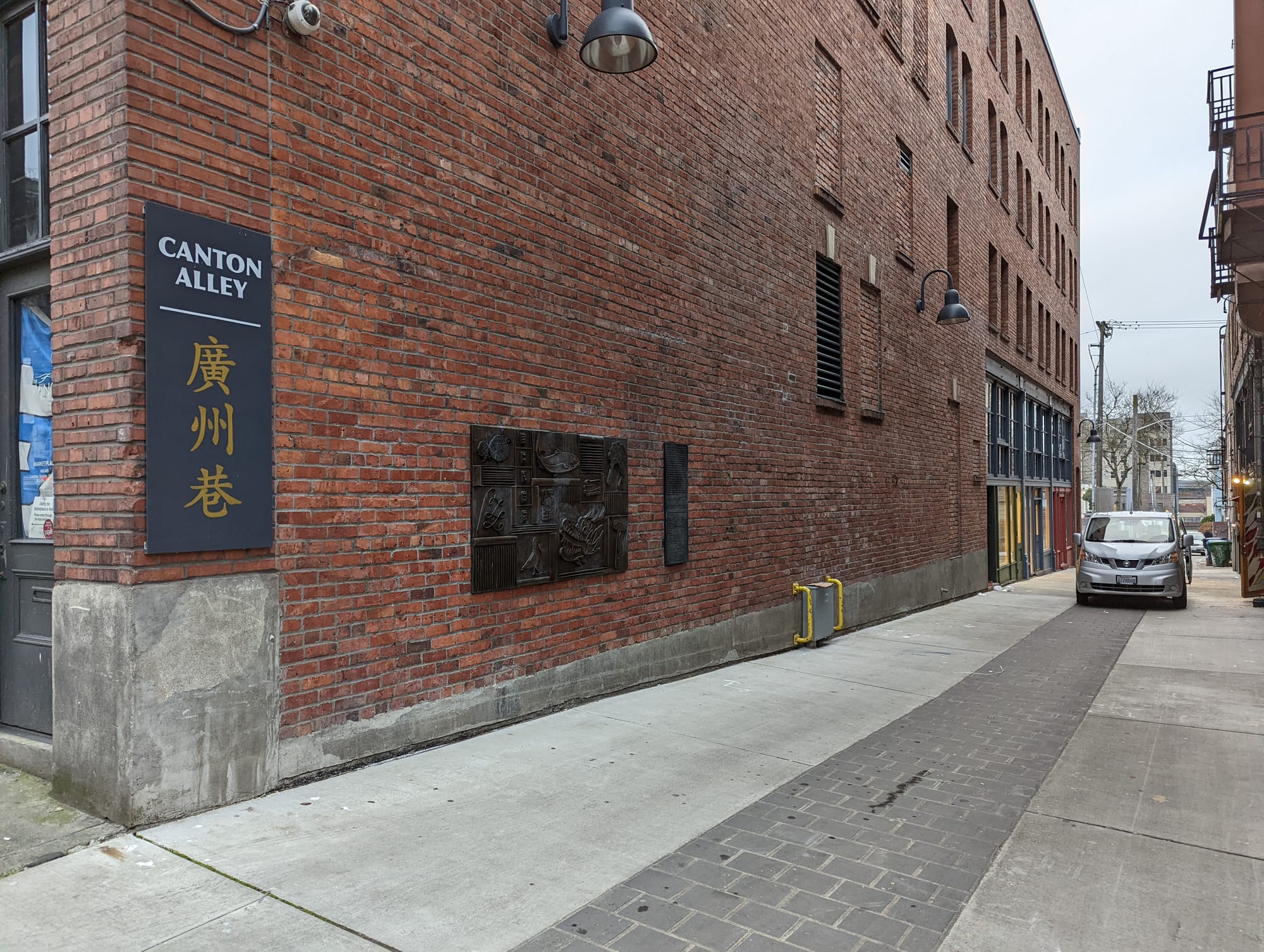 Canton Alley with a sign, the ground is recently repaved. Brick buildings surround it.