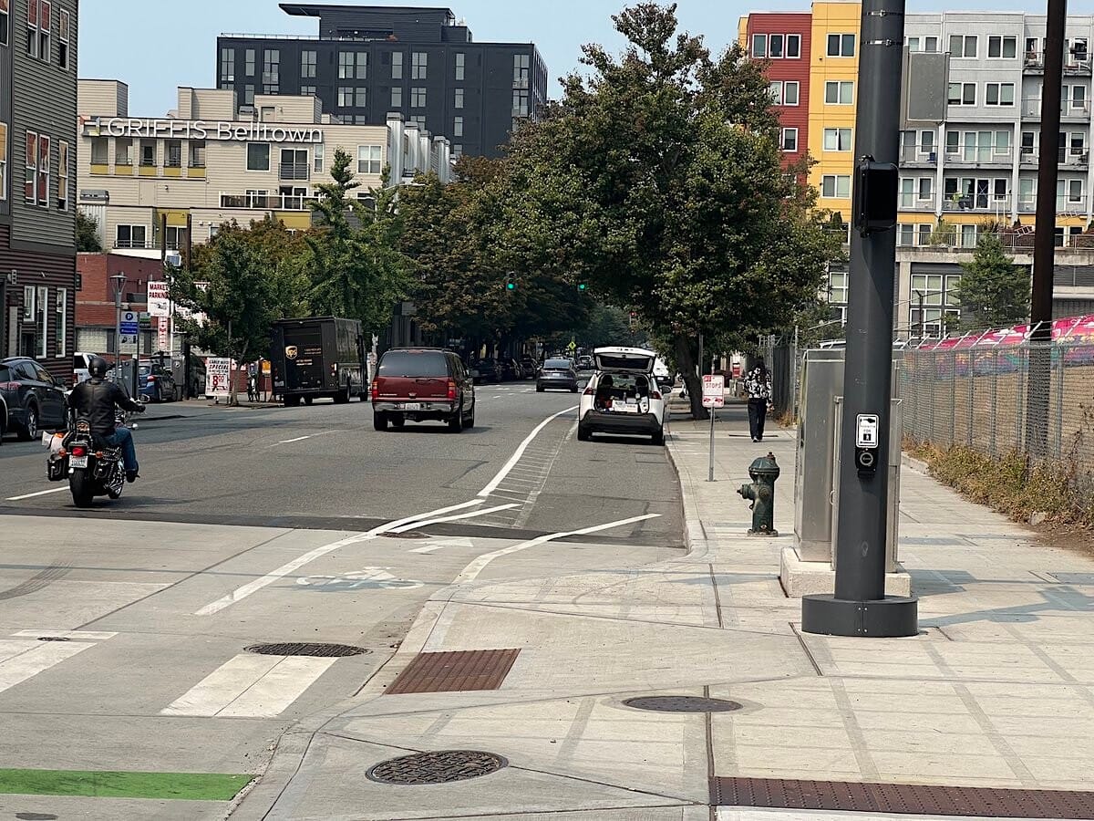 
                     Looking down Western Avenue at a white car in the bike lane.
                     