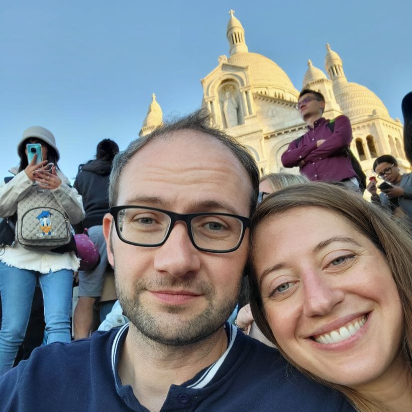 Jesse and his wife in front a stone church in Mexico City with other tourists nearby.