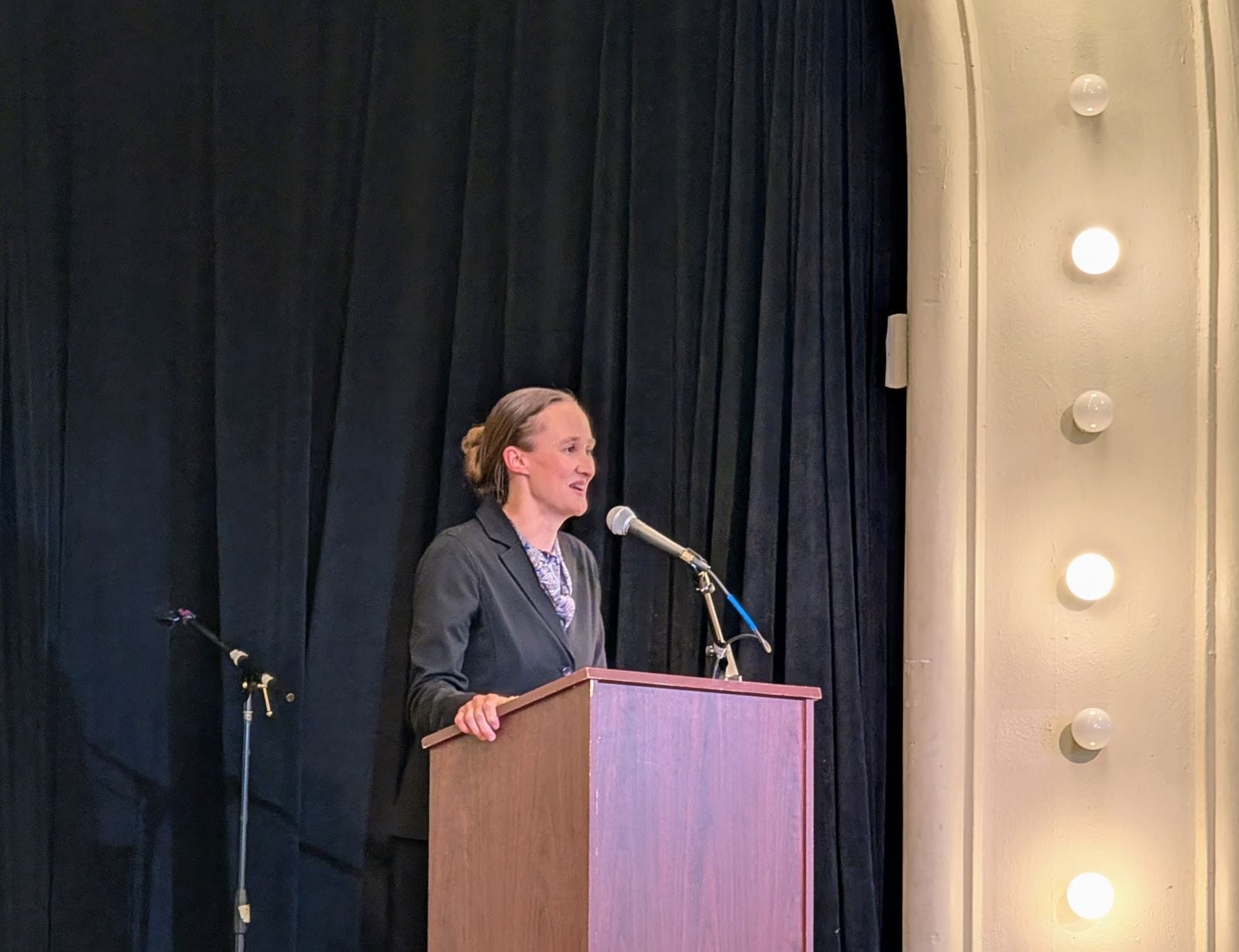 Wilson stands gripping a lectern on the Washington Hall stage.