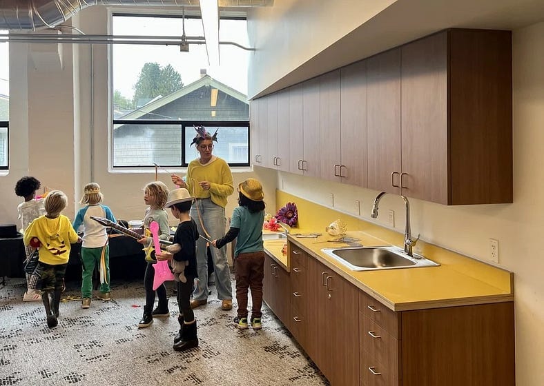 A day care worker and a group of kids in play costumes.