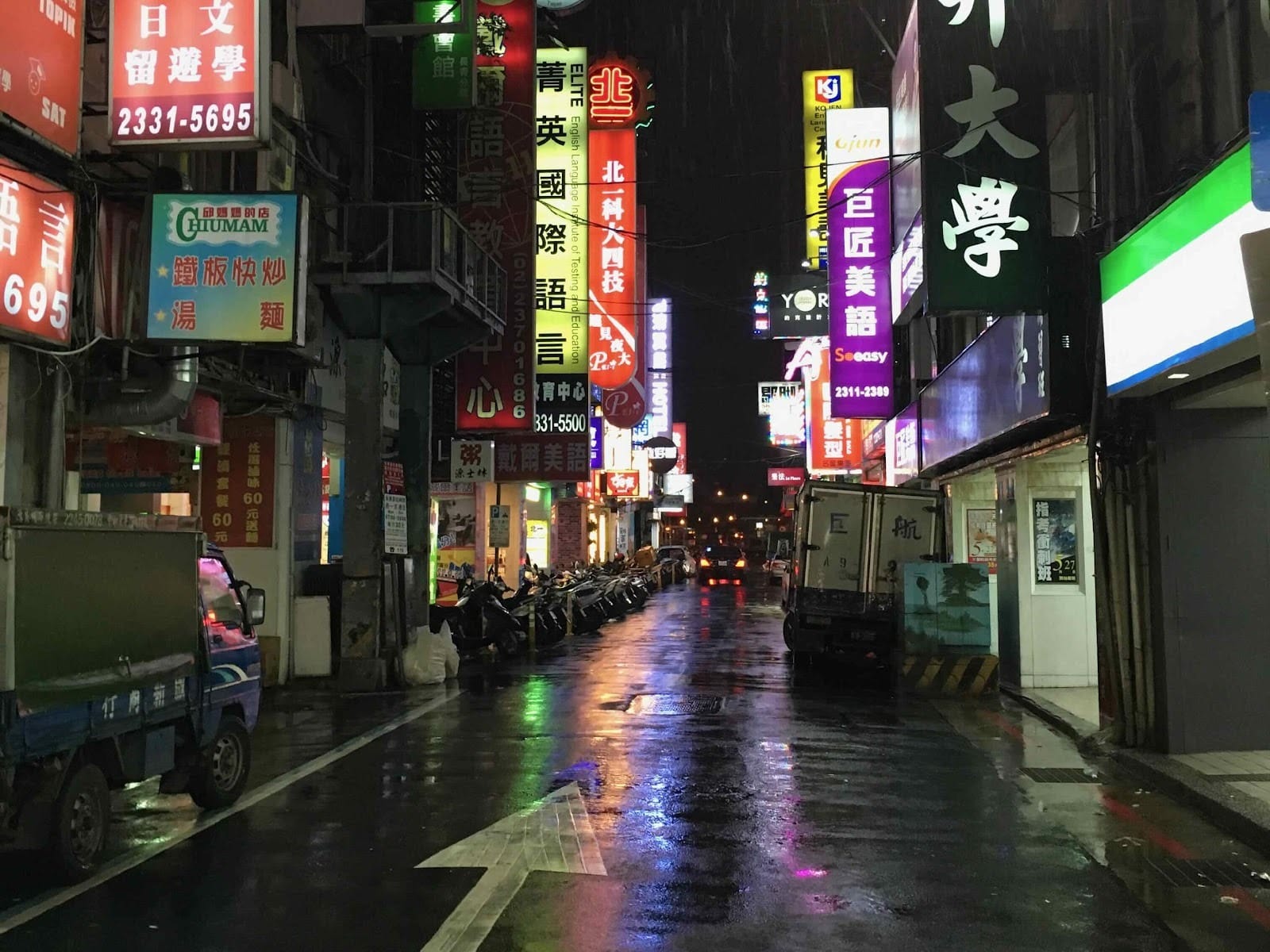 Bright signage lighting a busy street at night.